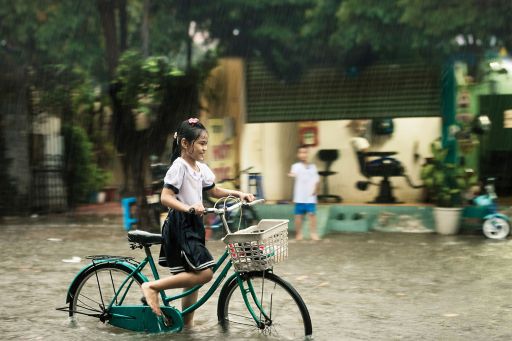 Girl on bicycle in rain