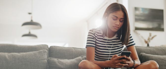 Girl sitting on couch using phone