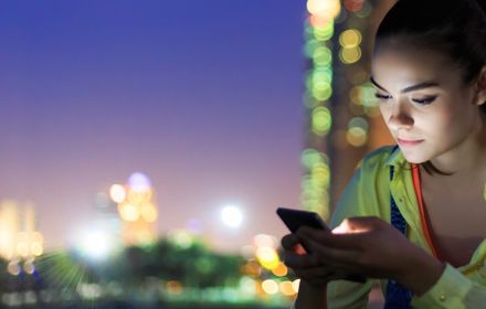 Girl using mobile phone in city night