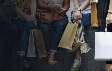 Group of women sitting together while having casual conversation holding shopping bags