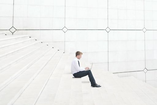 Guy with laptop types on steps