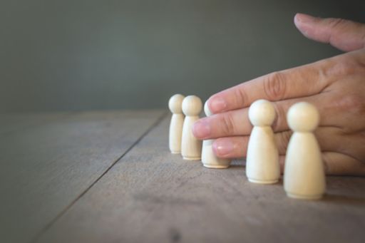 hand prevents a wooden dall from its group