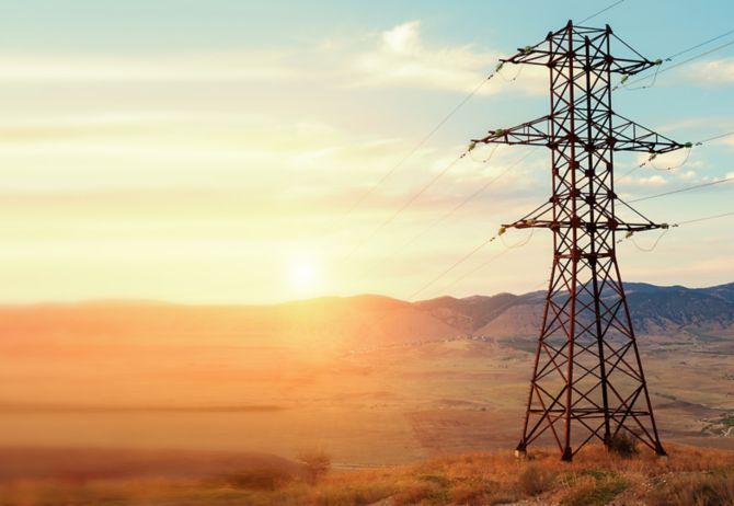 High voltage tower in mountains at sunset
