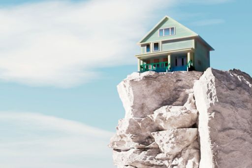 house on top of a high stony beach cliff