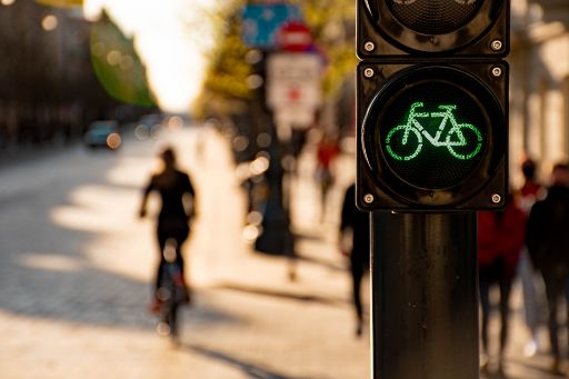 Green bike traffic light with cyclist in background