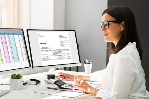 Woman working on multiple screens