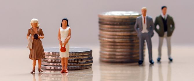 Miniatures of men and women beside stacks of coins, denoting the gender pay gap