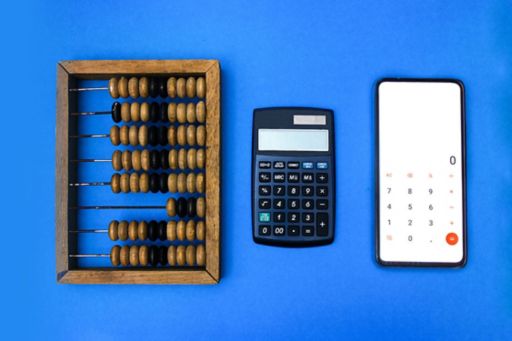 Abacus, calculator and smartphone on blue background