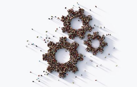 People, seen from above, arranged into a cog pattern