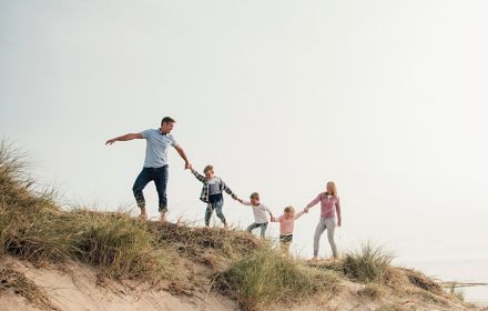 Family playing on sand dunes