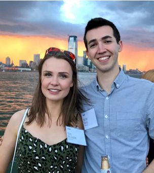 Two people with cityscape in the background at sunset