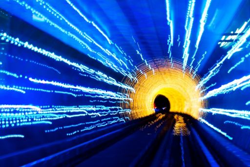 Train tunnel illuminated with blue and yellow 