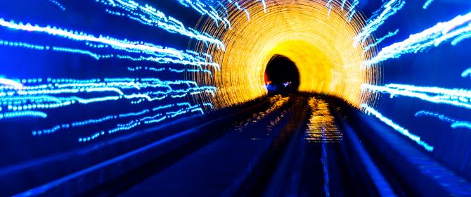 Train tunnel illuminated with blue and yellow 