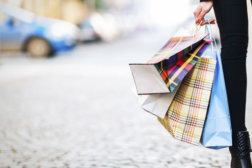 Revenue | Woman in black leggings holding several shopping bags 
