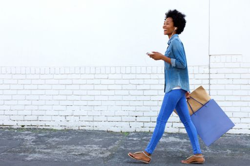 Woman in blue shirt holding shopping bags