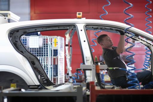 自動車組み立て工場で部品を取り付ける男性