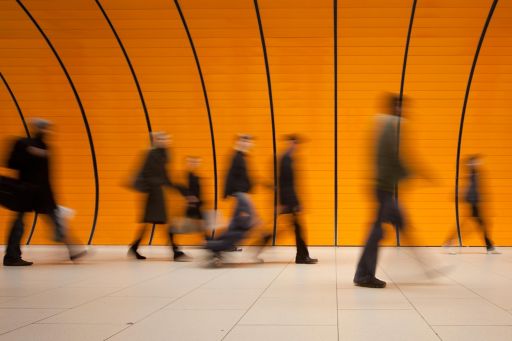 Group of people walking through a modern orange subway