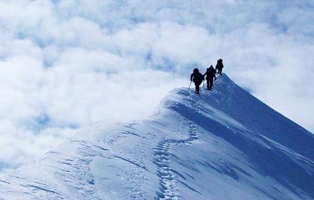 Low angle view of hikers on snowy mountain