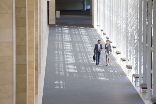 Businessman and businesswoman walking in lobby of modern office