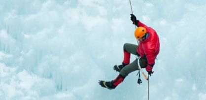 man rappelling on ice during winter