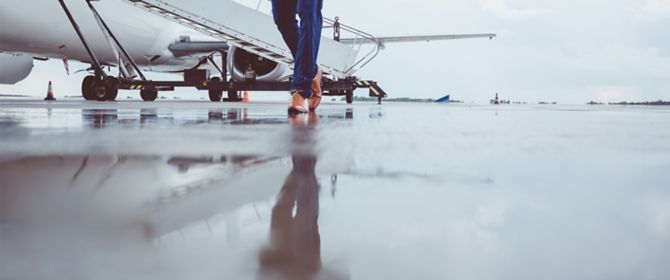 Man walking on runway with private jet in background