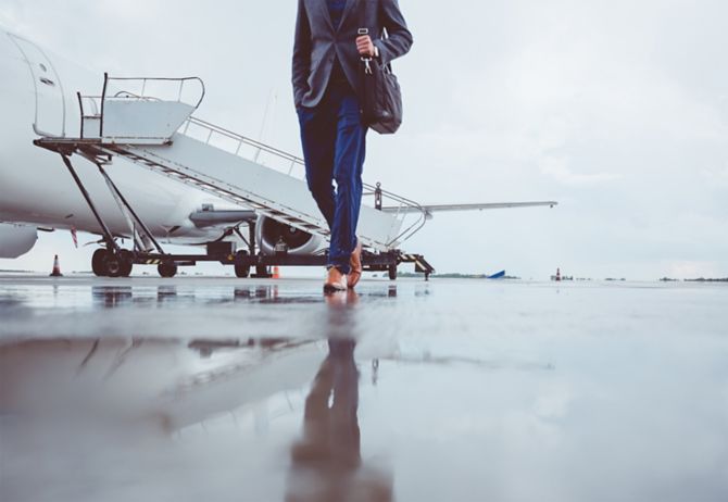Man walking on runway with private jet in background