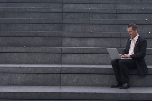 Man with laptop sitting on stairs