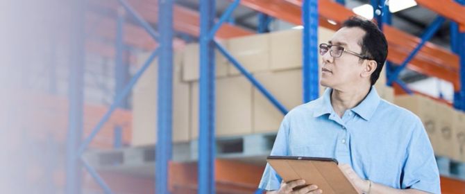 Man in warehouse using tablet