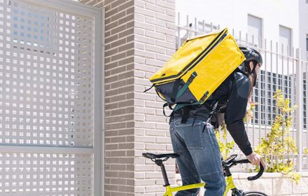 Men riding yellow cycle with yellow backpack