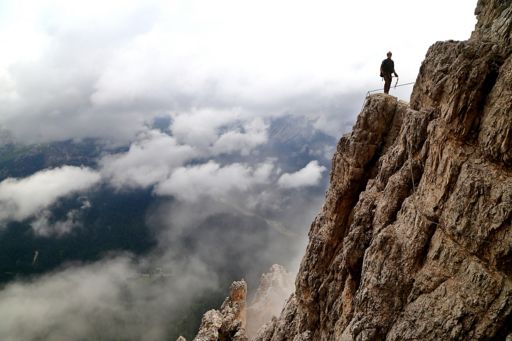 Mountaineer standing on mountain in clouds