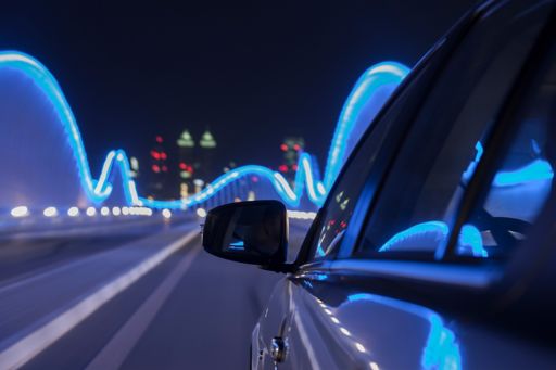 Moving car on a bridge with blue lights at night