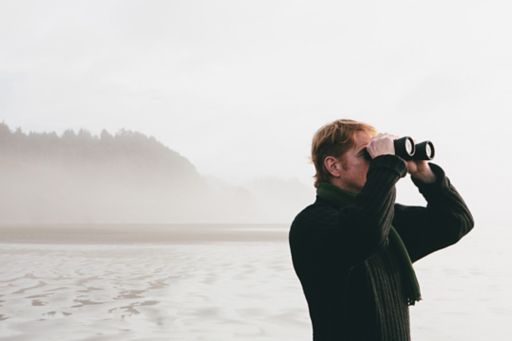 man looking through binoculars