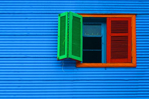 Red and green color open window against blue wall