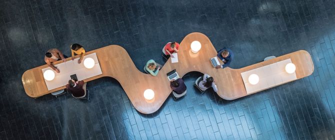 Overhead view of business meeting on a curvy table