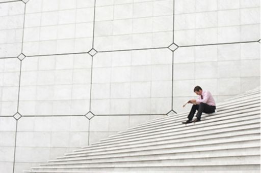 Mężczyzna siedzący na schodach; zdjęcie z okładki raportu "Enabling the future of underwriting"
