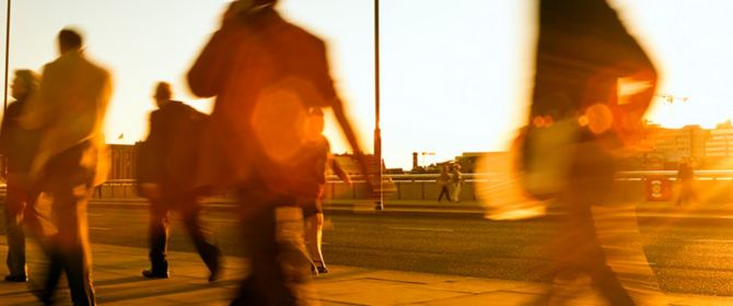 Menschen laufen bei Sonnenuntergang