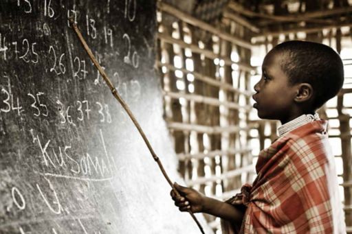 A boy solving a problem on a chalkboard