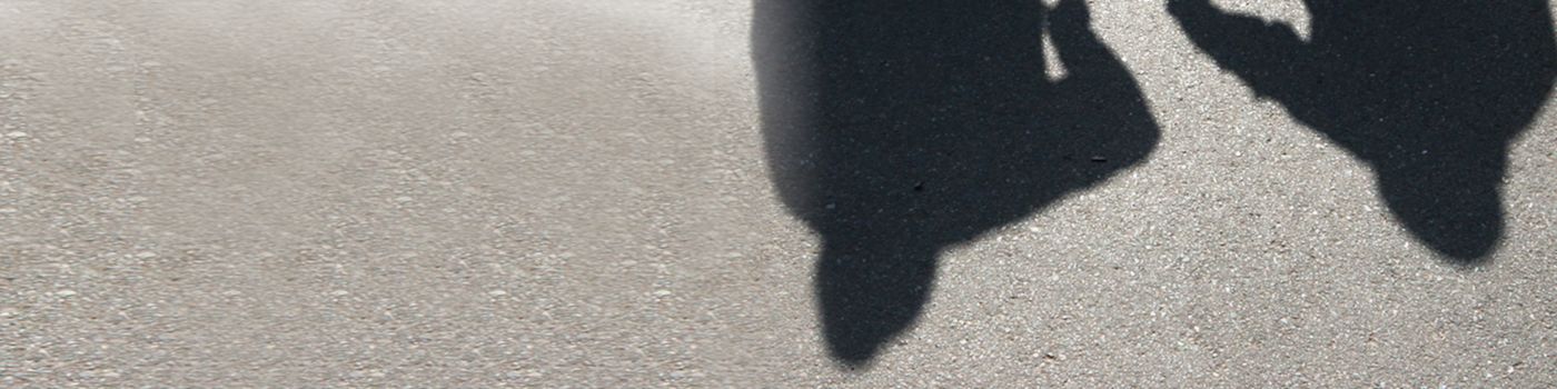 shadows behind two adults carrying a child