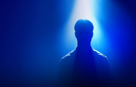 Silhouette of man standing under spotlight