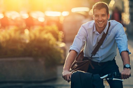 Smiling man riding bike in city