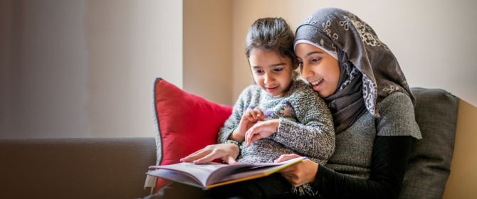 Girl wearing hijab sits with sister