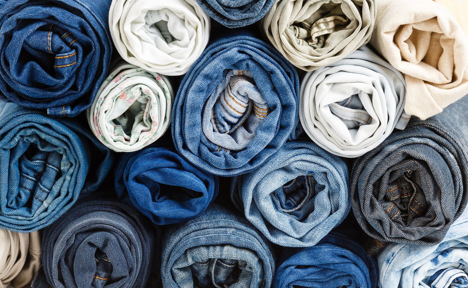 Stack of different rolled denim jeans