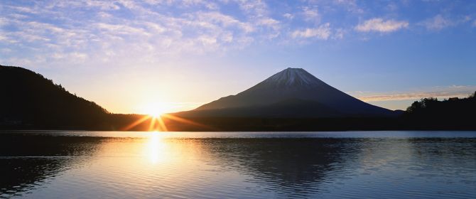 KPMG IFRS disclosures topic image: sun rising behind mountains and a body of water.