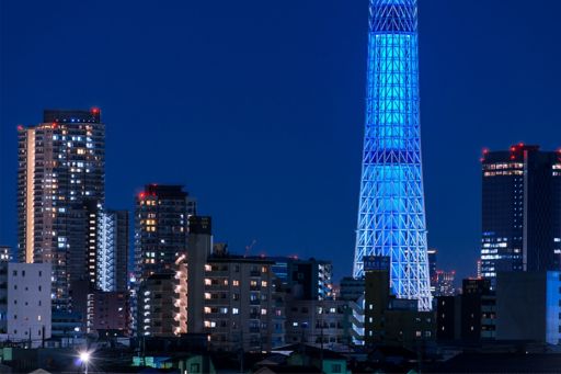 The view of buildings in Tokyo under the blue night sky.