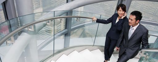 Two business people climbing stairs