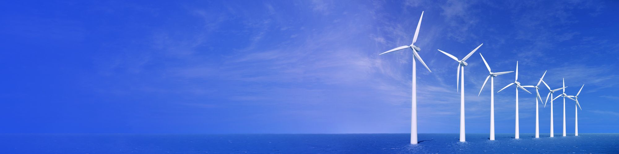 White wind mill in sea against clear blue sky