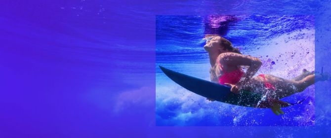 woman being underwater with surfboard