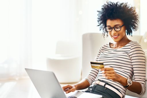 Woman holding credit card with laptop