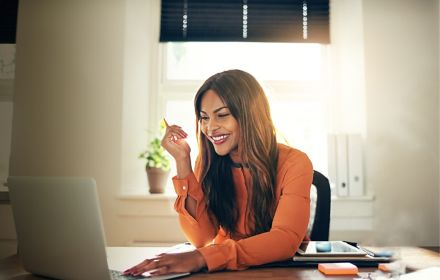 Woman smiling while looking at laptop