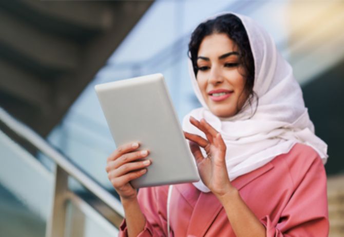 woman wearing headscarf using tablet